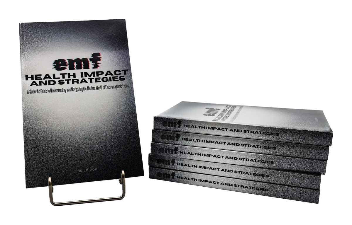 EMF Health Impact and Strategies book on a stand beside a stack of copies