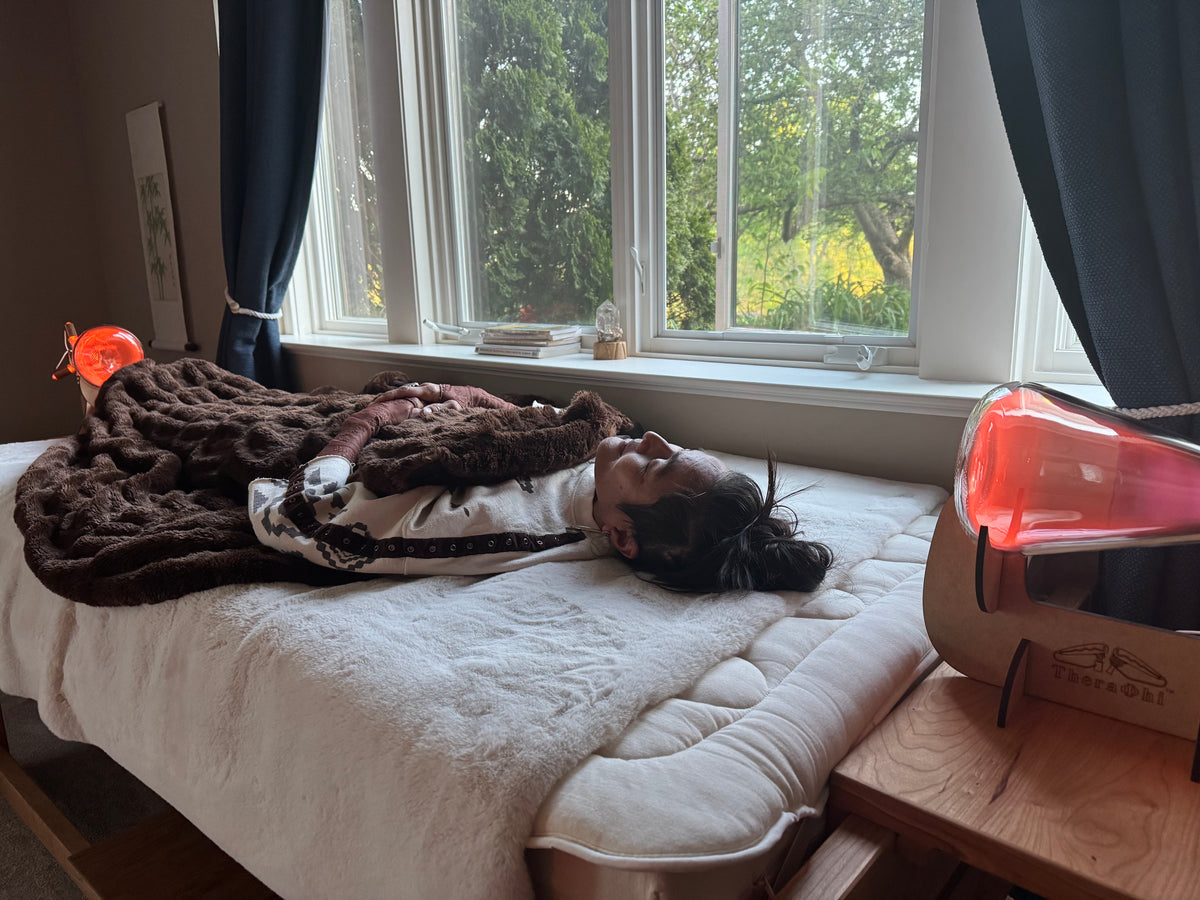 beautiful asian woman laying on a bed between theraphi bulbs