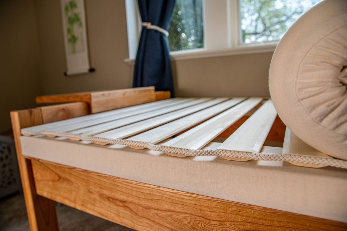 theraphi bed in front of a window. pulling back the matttress to show the bed frame underneath